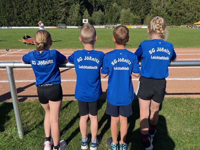 4 Kinder der SG Jößnitz, Abteilung Leichtathletik schauen auf den Sportplatz